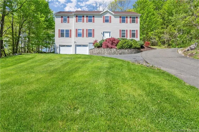 40 S King Street, Danbury — colonial with a two-car garage above a stone retaining wall and sloping lawn
