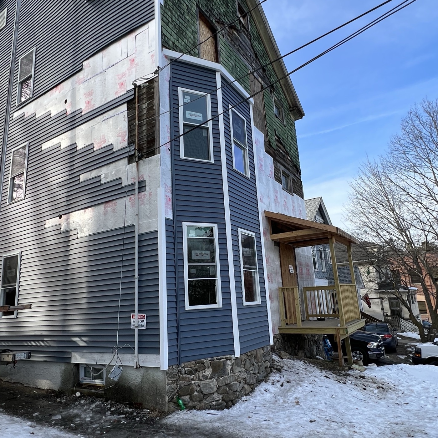 The bay corner of 329 Oak Street in January, half sided, housewrap and old green shingle still exposed