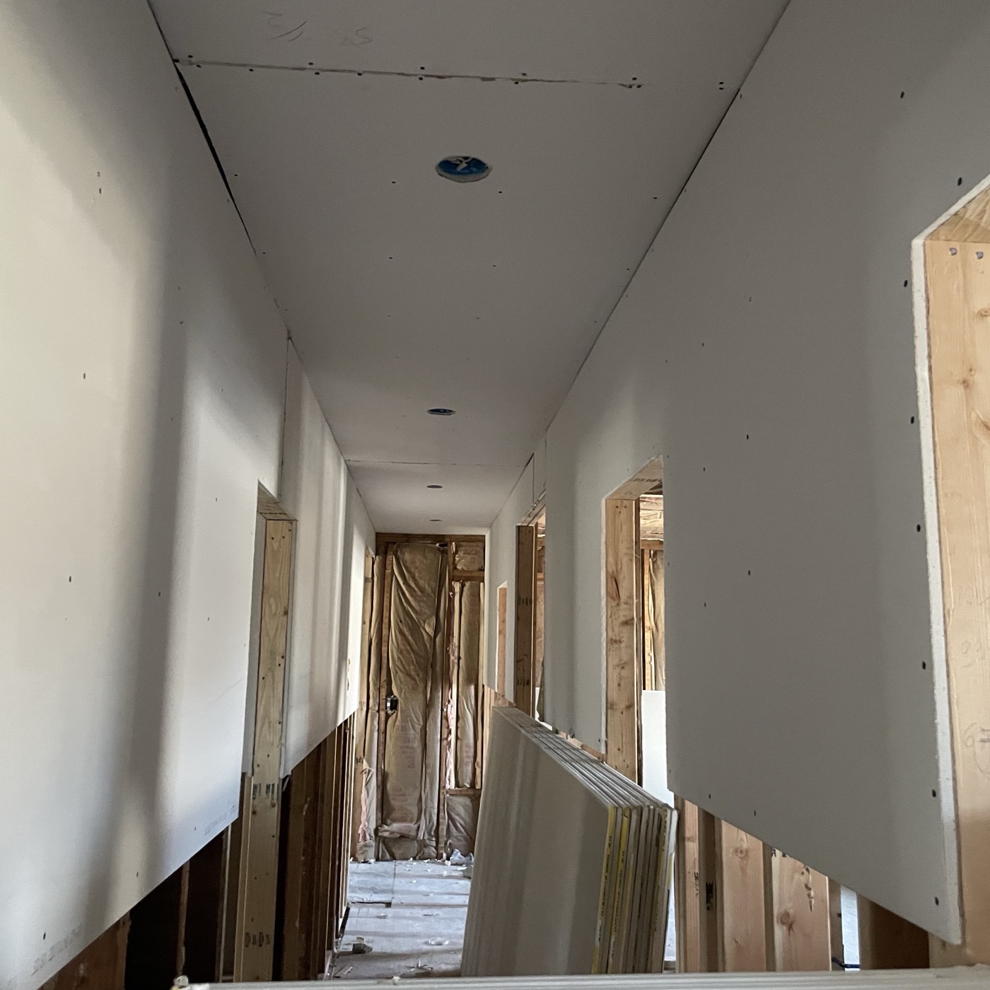 The same hallway eight days later with drywall hung and openings framed